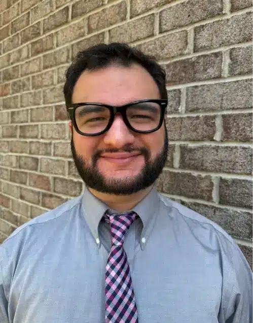 Professional headshot of Tony Prieto, Marketing Strategist at Answering Legal, smiling in front of a brick wall.